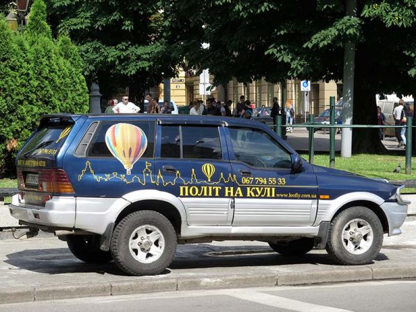An SUV with hot air ballon advertisement on the side